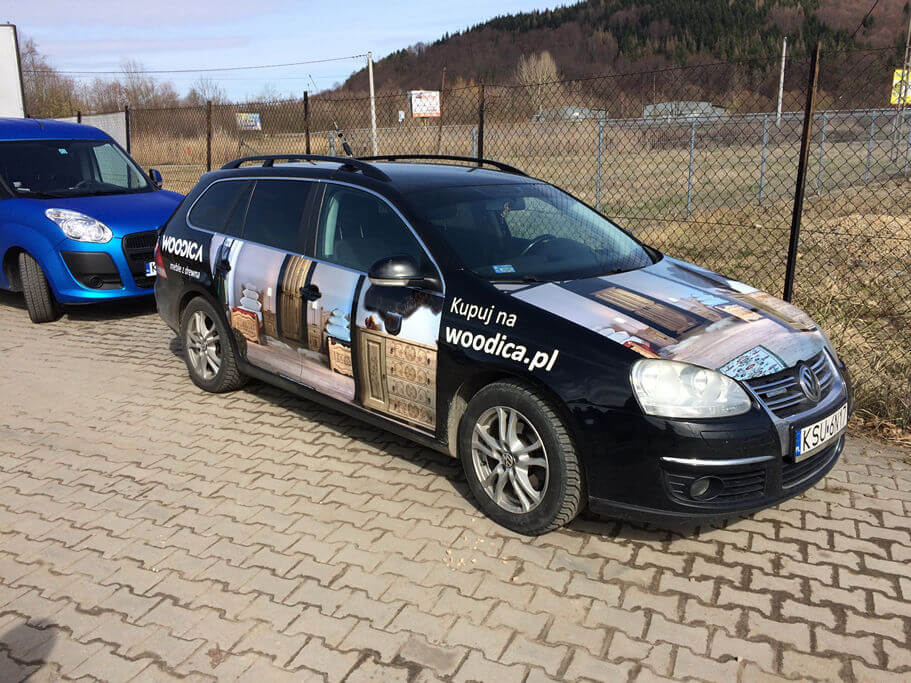 Oklejenie samochodu osobowego dla firmy WOODICA wykonane folią monomeryczną zabezpieczoną laminatem płynnym. WOODICA